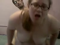 Geeky amateur girl squeezes her big tits while being slammed from behind by her partner